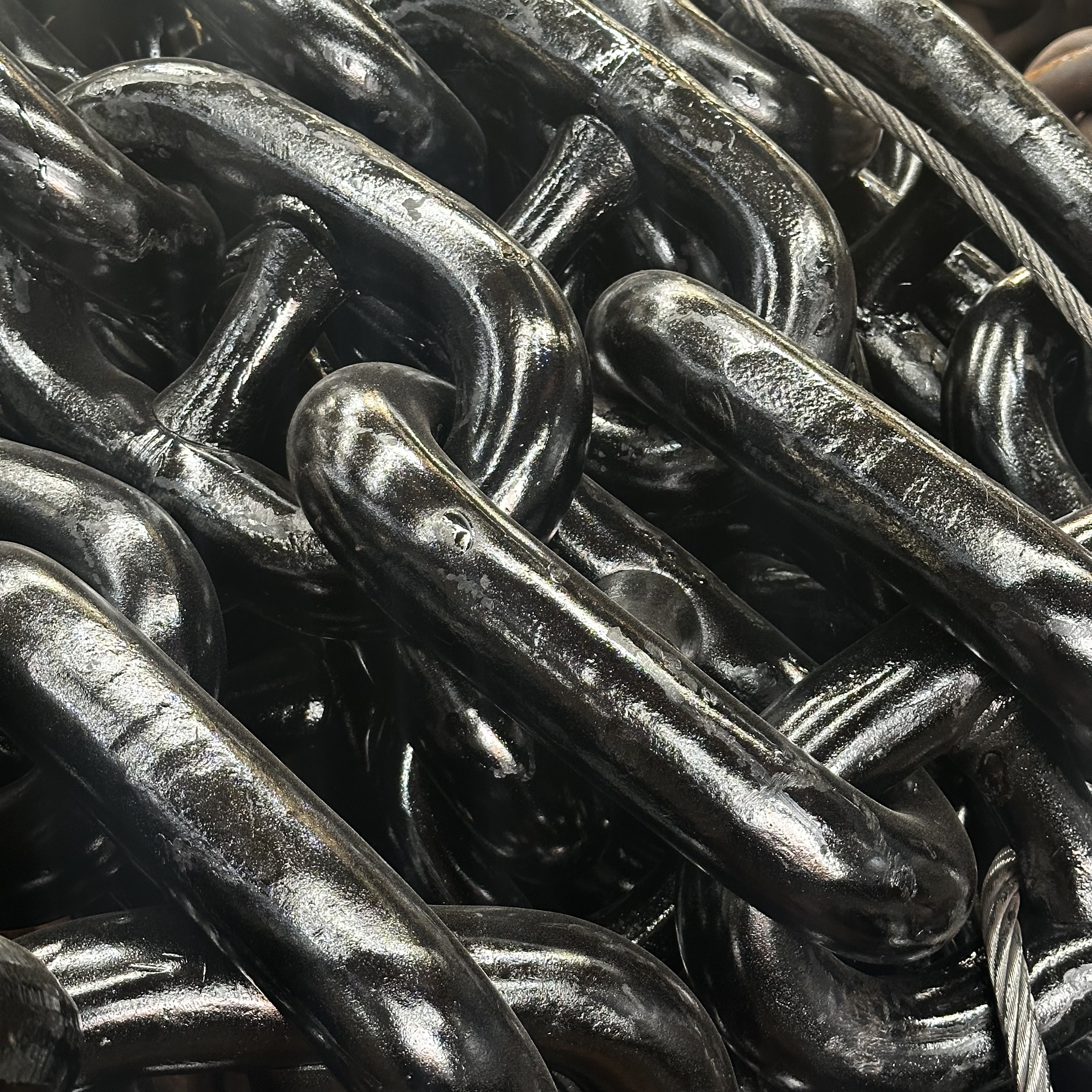 Showcase of manufactured products including metal chains, industrial components, and precision parts arranged on clean workbench with measuring tools and technical drawings in background